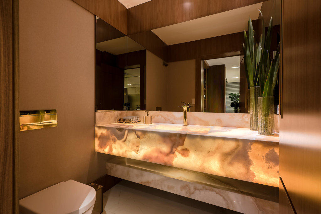 lavabo decorado com cuba esculpida com luz e monocomando dourado